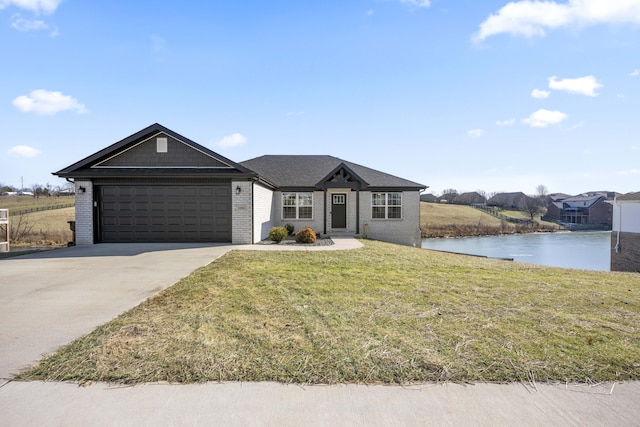 single story home with a garage, a front lawn, and a water view