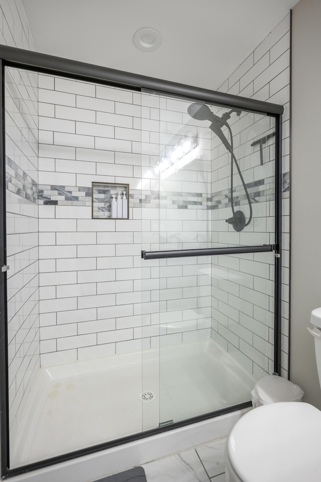 bathroom with an enclosed shower and toilet