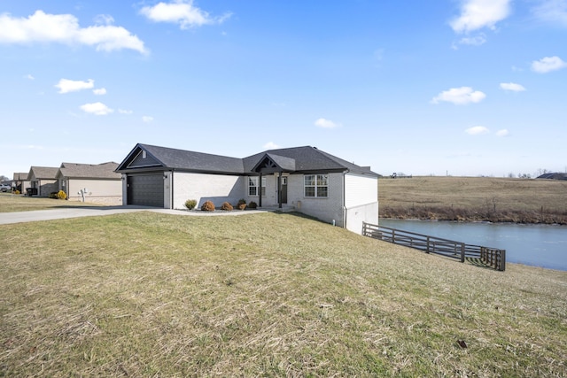 view of front of house with a garage, a water view, and a front lawn