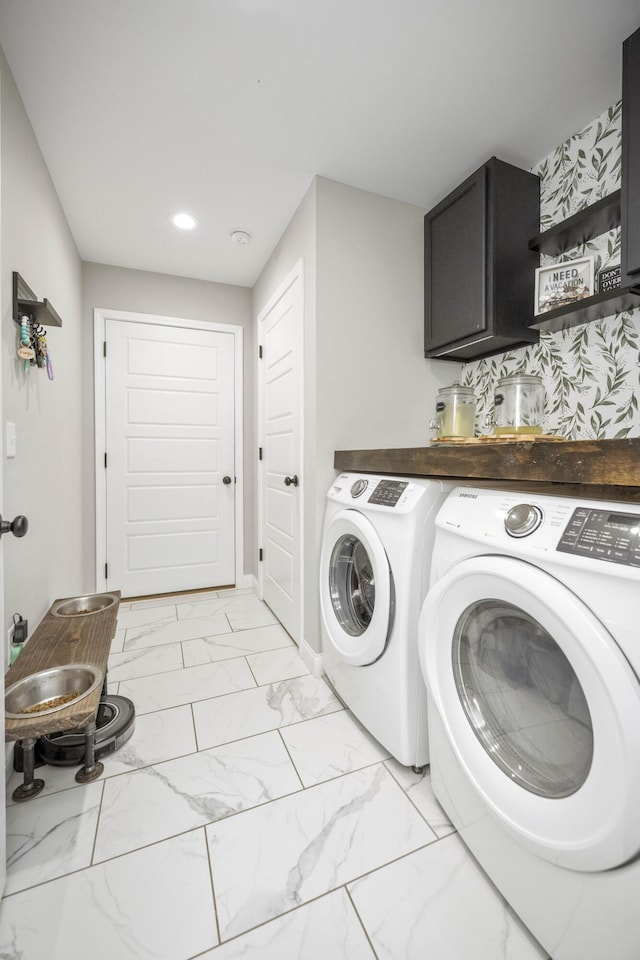 laundry area with washing machine and dryer and cabinets