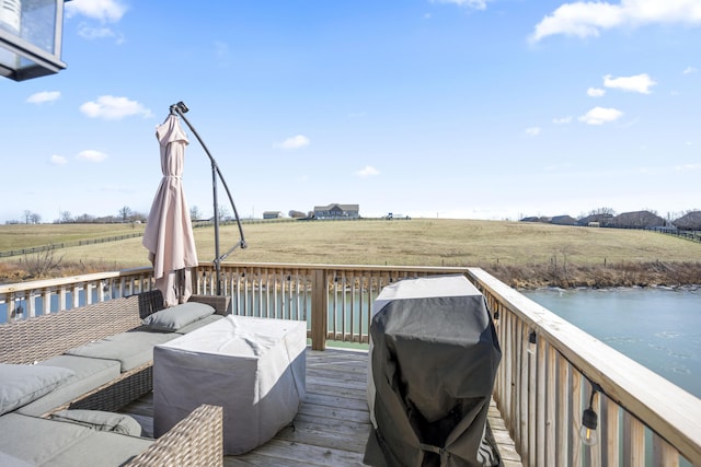 deck with a rural view, grilling area, and a water view