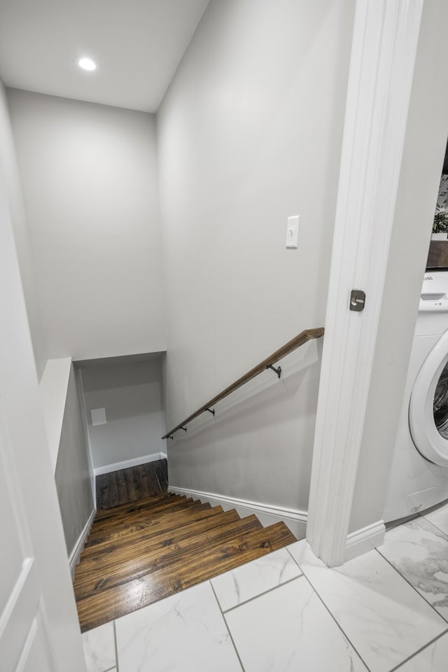 stairway featuring wood-type flooring and washer / dryer