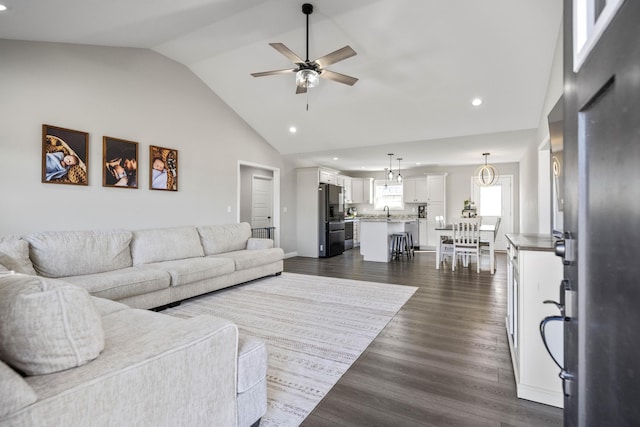 living room featuring ceiling fan, lofted ceiling, sink, and dark hardwood / wood-style flooring