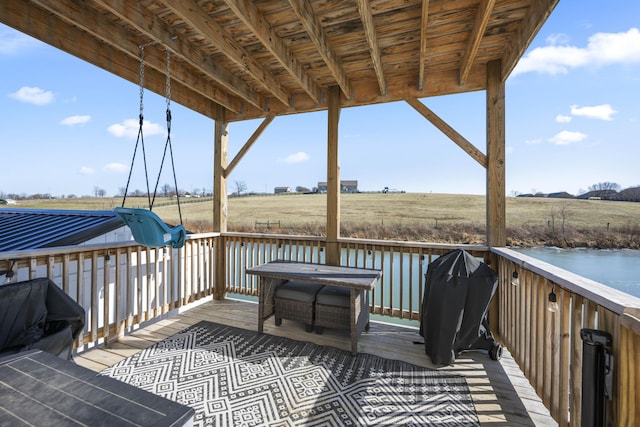 wooden deck with a rural view and grilling area