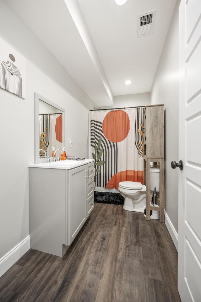 bathroom featuring hardwood / wood-style flooring, vanity, a shower with curtain, and toilet