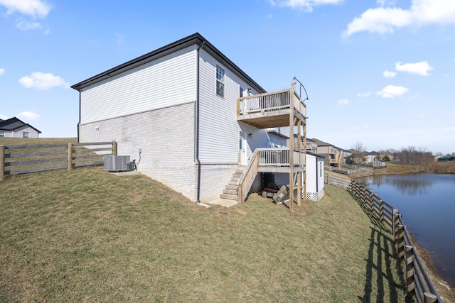 view of property exterior with a deck with water view, central AC unit, and a lawn