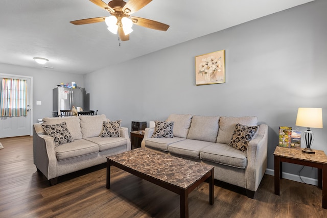 living room with ceiling fan and dark hardwood / wood-style flooring