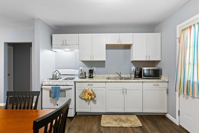 kitchen featuring dark hardwood / wood-style floors, sink, white gas stove, and white cabinets