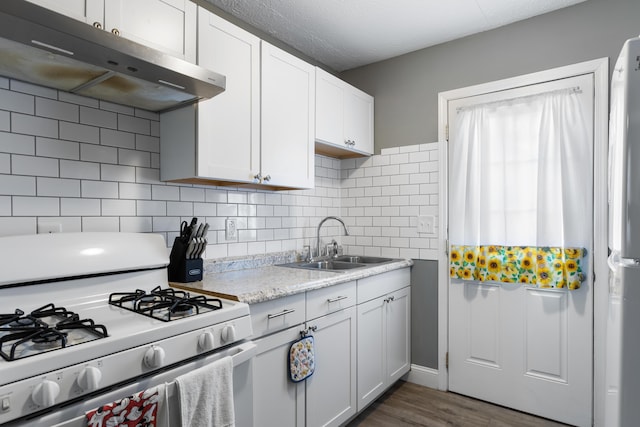 kitchen with tasteful backsplash, white appliances, sink, and white cabinets