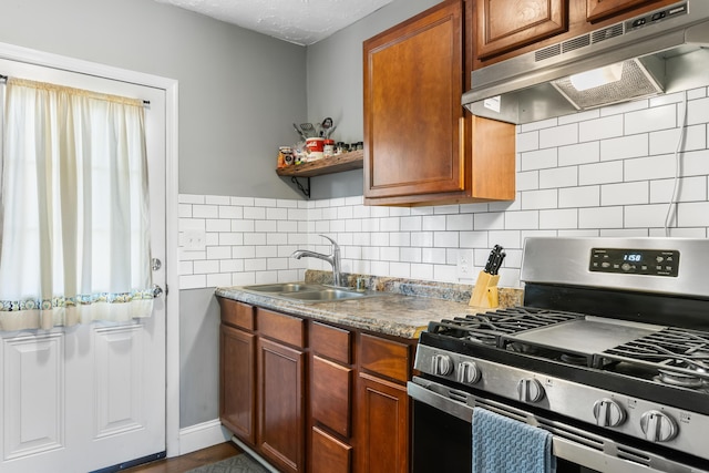 kitchen featuring gas range, sink, and a textured ceiling