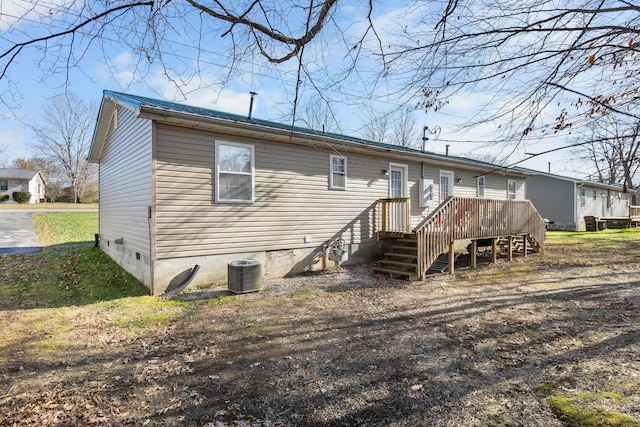 rear view of house with cooling unit and a wooden deck