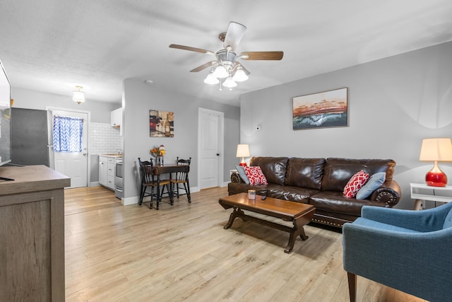 living room featuring ceiling fan and light hardwood / wood-style flooring