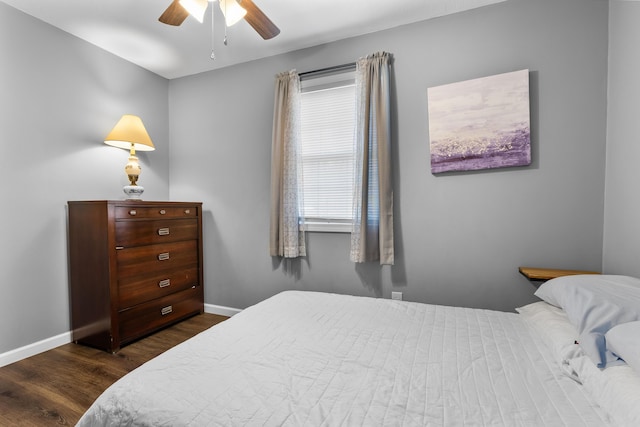 bedroom with dark hardwood / wood-style flooring and ceiling fan