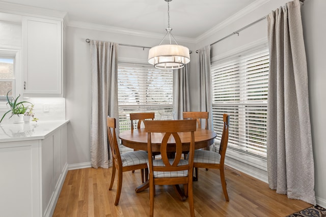 dining space featuring crown molding and light wood-type flooring