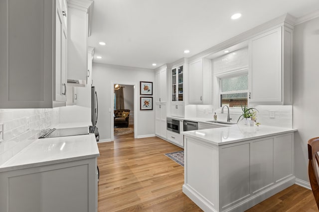 kitchen featuring tasteful backsplash, sink, white cabinets, and light wood-type flooring