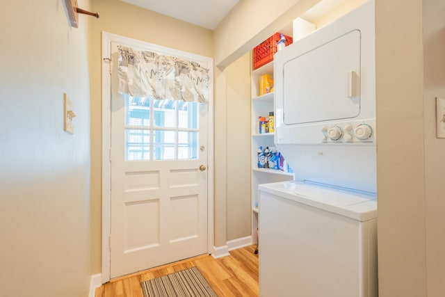 clothes washing area with stacked washer and dryer and light hardwood / wood-style floors