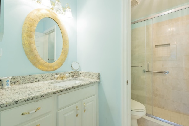 bathroom with walk in shower, vanity, and toilet