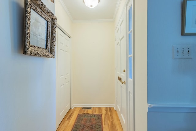 hall featuring ornamental molding and light hardwood / wood-style flooring