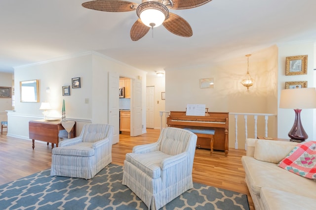 living room featuring hardwood / wood-style flooring, ornamental molding, and ceiling fan