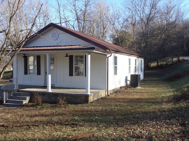 view of front of home featuring covered porch, a front yard, and central air condition unit