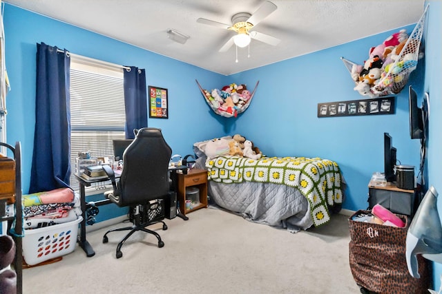 carpeted bedroom with ceiling fan and a textured ceiling