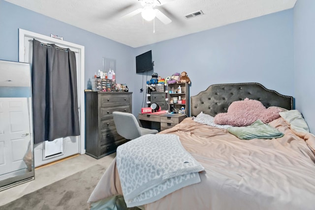 carpeted bedroom with a textured ceiling and ceiling fan