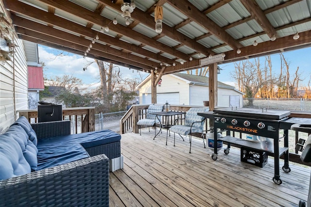 deck with an outdoor living space, a garage, and an outbuilding