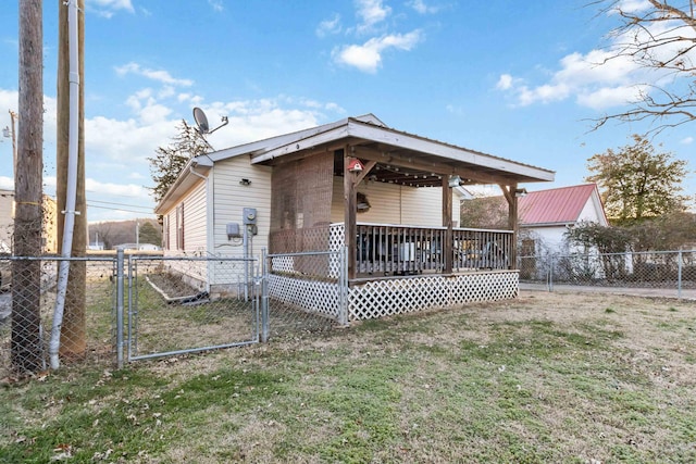 back of property with a deck and a lawn