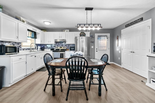 dining space featuring sink and light hardwood / wood-style flooring