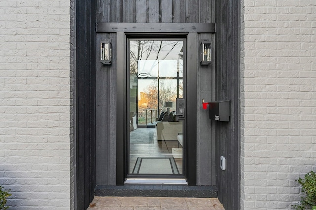 view of exterior entry with brick siding