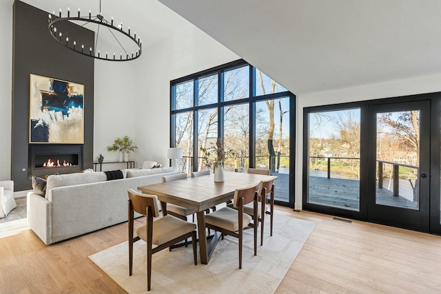 dining area with a healthy amount of sunlight, a notable chandelier, and light hardwood / wood-style flooring