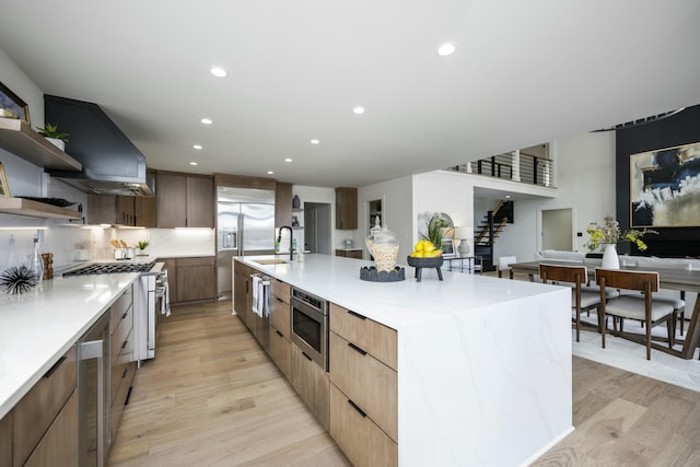 kitchen featuring built in appliances, light wood-style floors, modern cabinets, and open shelves