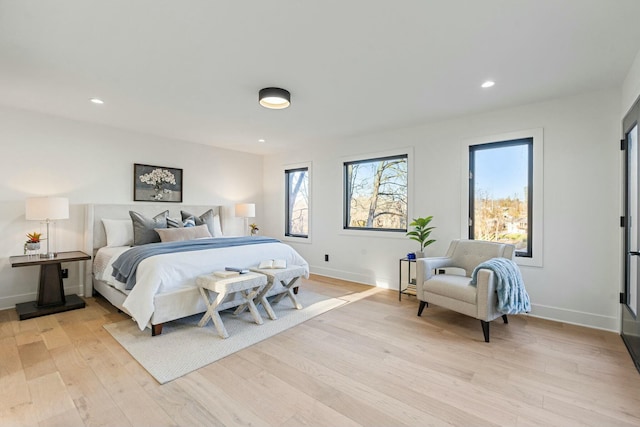 bedroom featuring multiple windows and light hardwood / wood-style floors