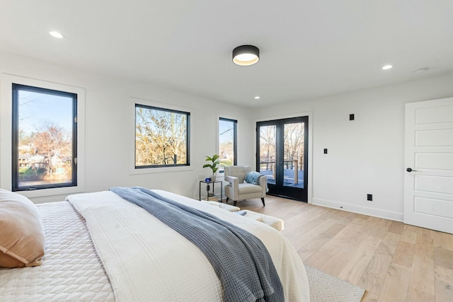 bedroom featuring access to exterior, light wood-type flooring, and french doors