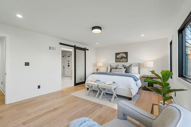bedroom featuring a barn door, light wood-type flooring, recessed lighting, and visible vents