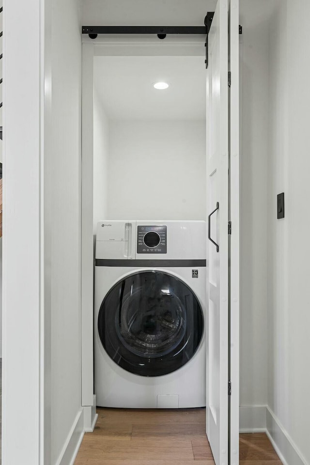 laundry room with wood finished floors, laundry area, and washer / clothes dryer