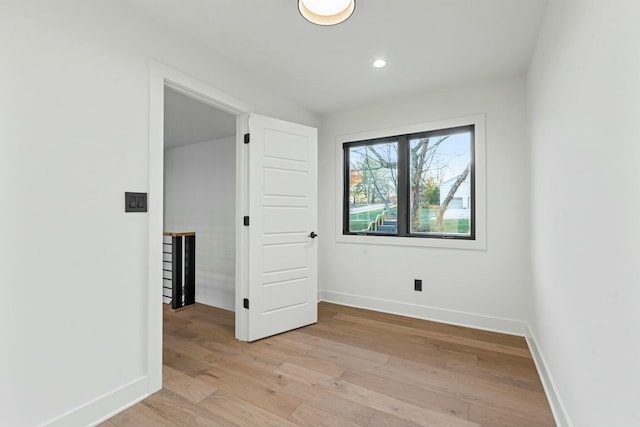spare room with baseboards, recessed lighting, and light wood-style flooring