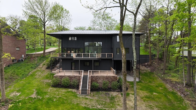 rear view of property with a deck, metal roof, and stairs