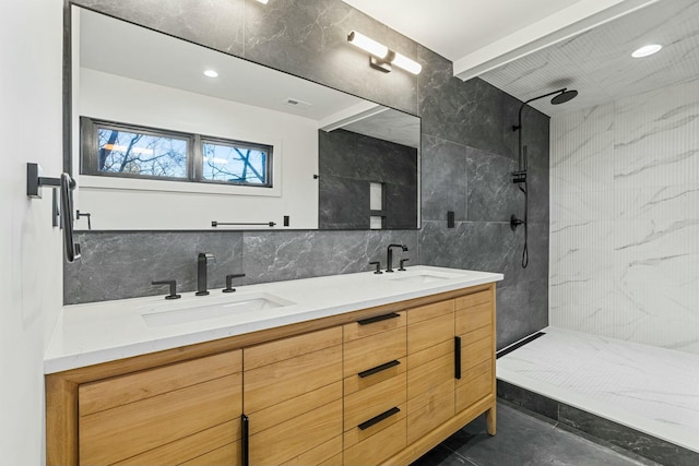 full bath featuring walk in shower, tile walls, a sink, and double vanity