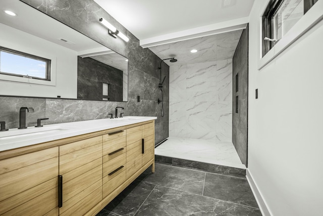 bathroom featuring tile walls, a sink, a marble finish shower, marble finish floor, and double vanity