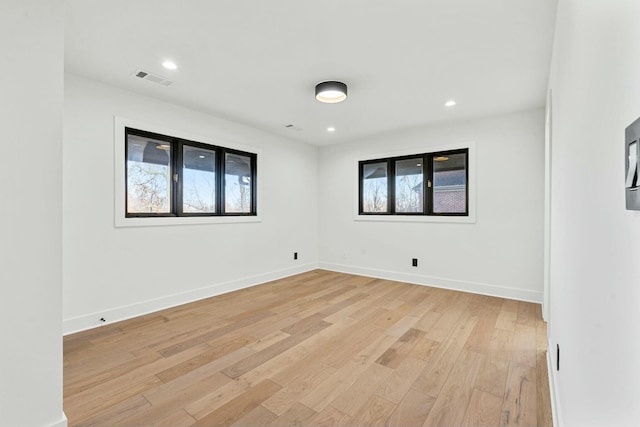 empty room featuring baseboards, visible vents, light wood-style flooring, and recessed lighting
