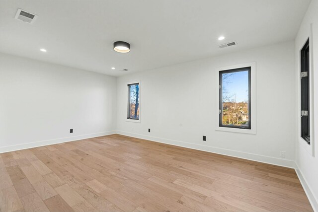 unfurnished bedroom with ensuite bathroom and light hardwood / wood-style floors