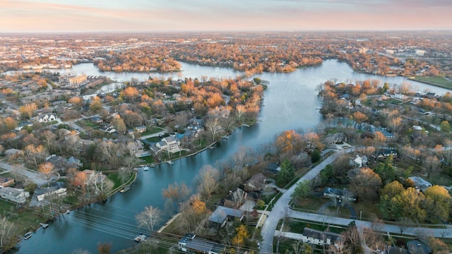 aerial view at dusk featuring a water view