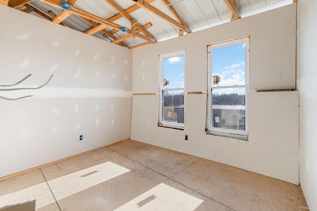 unfurnished room with vaulted ceiling