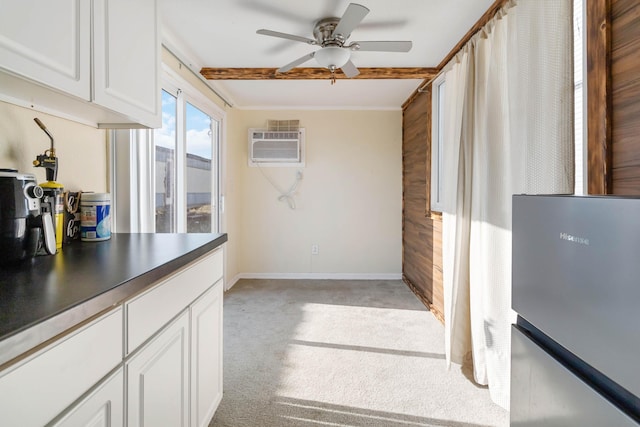 kitchen featuring white cabinetry, a wall mounted air conditioner, ceiling fan, beamed ceiling, and light colored carpet