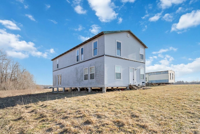 rear view of property featuring a yard