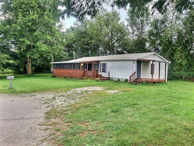 view of front facade with a sunroom and a front yard