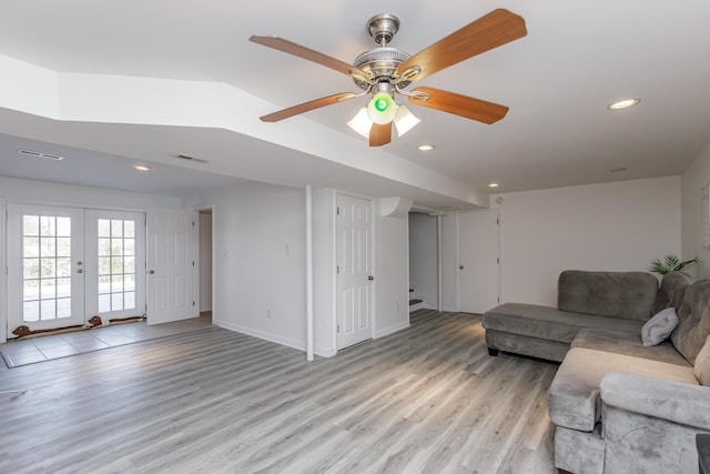 living room with french doors, ceiling fan, and light wood-type flooring