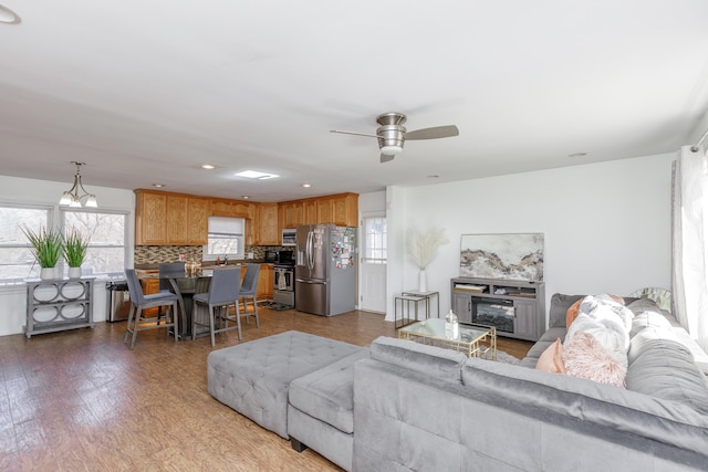 living room featuring wood-type flooring and ceiling fan with notable chandelier