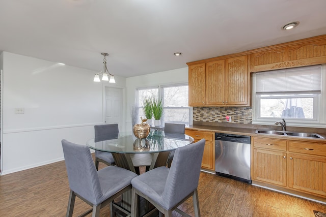 kitchen featuring sink, dark wood-type flooring, backsplash, decorative light fixtures, and stainless steel dishwasher